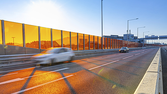 Photo: Schräger Blick auf Autobahn mit Lärmschutzwand im Sonnenlicht