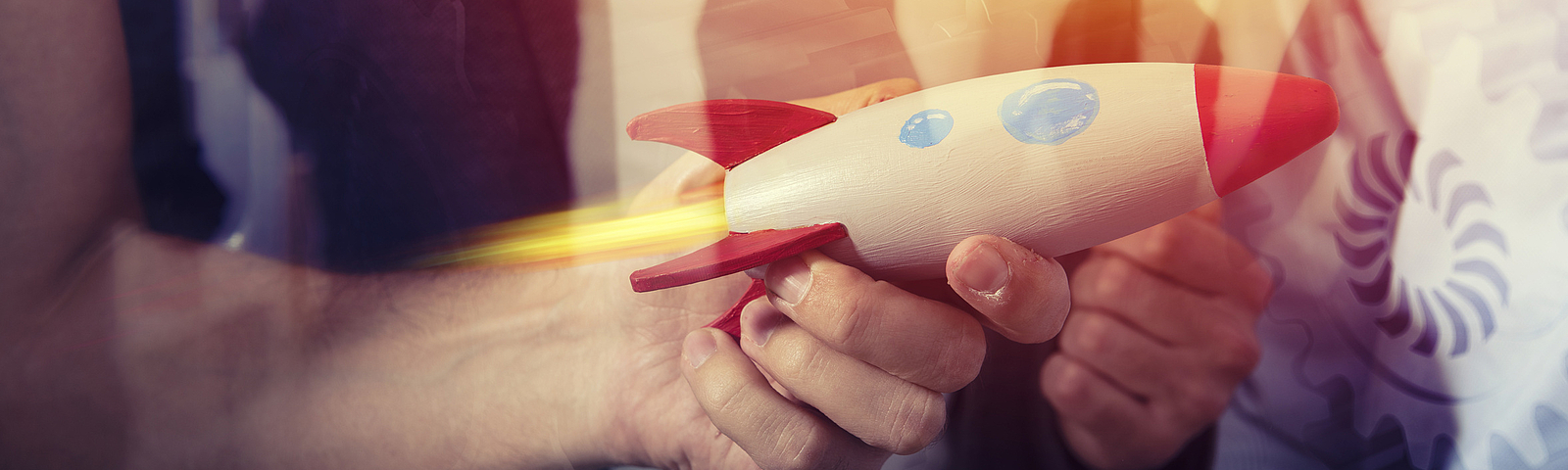 Photo: Hand hält eine Rakete aus Holz