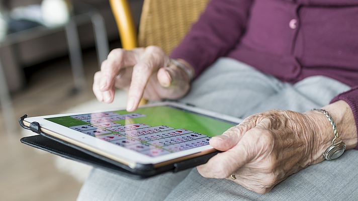 Photo: Ältere Dame tippt am Tablet