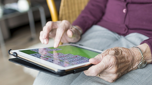Photo: Ältere Dame tippt am Tablet