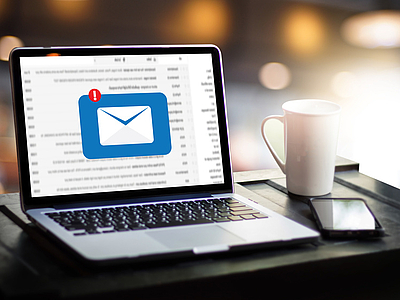Photo: Laptop auf einem Tisch mit einem großen Brief/Email Icon am Bildschirm 