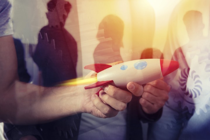 Foto: Hand hält eine Holzrakete 